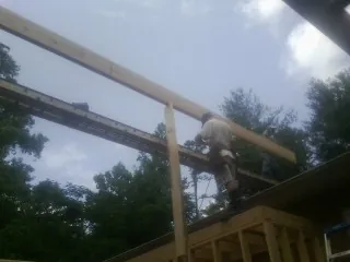 Carpenter setting a ridge beam over a new addition frame — Ice Dam Removal by Roofing Brothers in Charlton