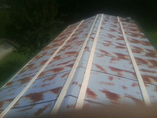 Rusted metal roof panels with new wood purlins before replacement — Storm Damage Roof Repair in Charlton by Roofing Brothers