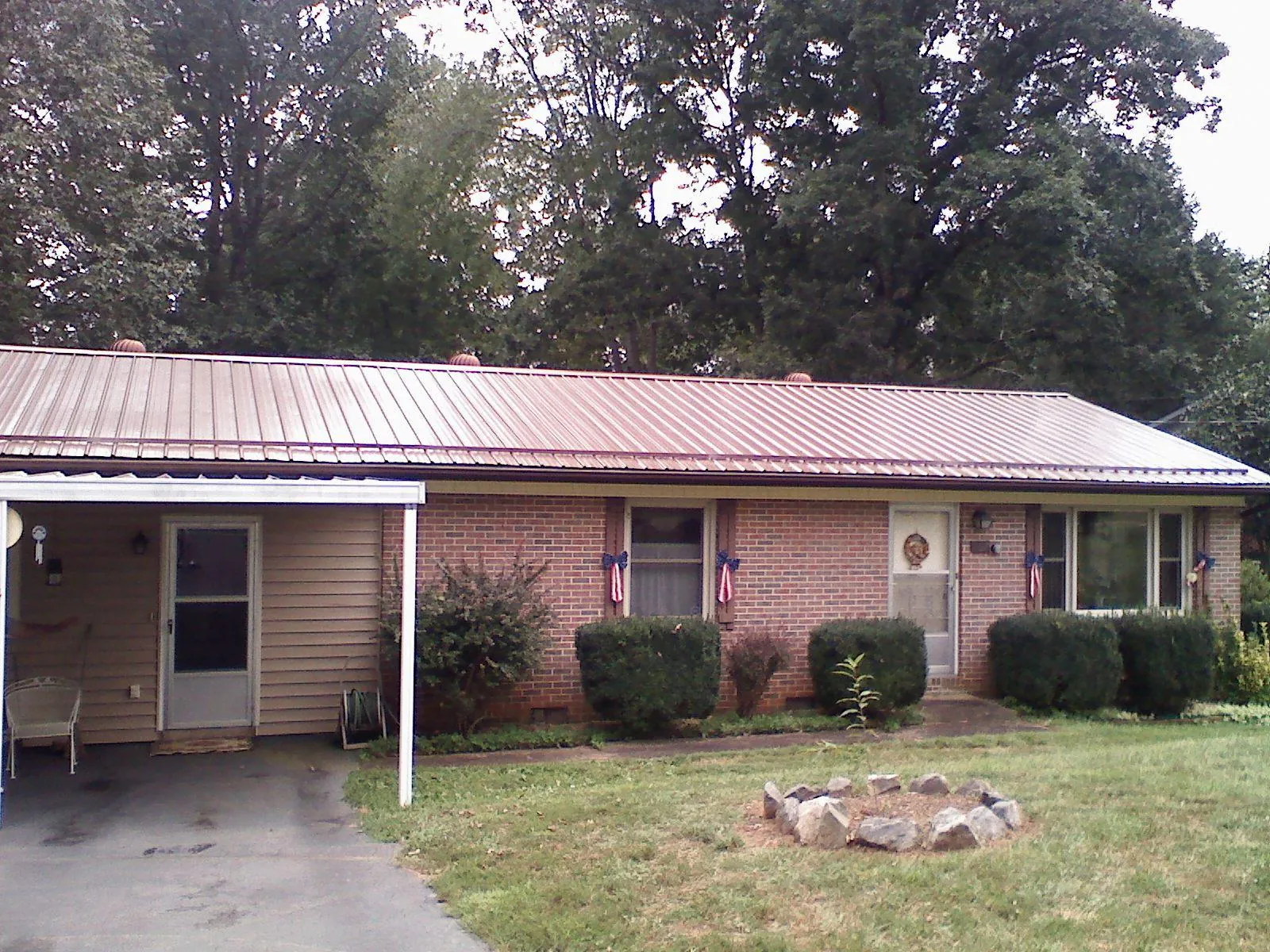 Bronze metal roof and carport on a brick ranch home — Roof Repair work by our crew in Charlton