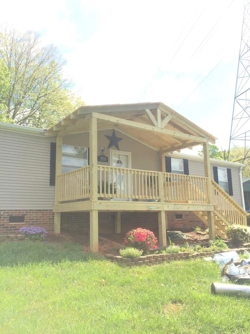 New gabled porch roof and deck railing added to a ranch home in Charlton